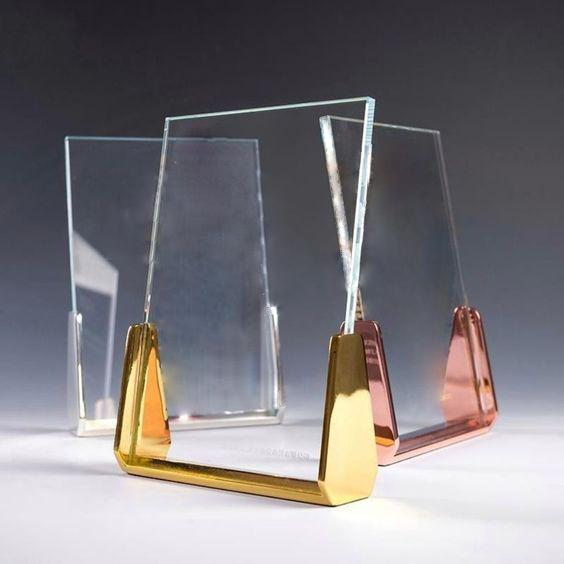 A polished crystal award with a refined, transparent design, elegantly shaped with sharp angles and smooth surfaces with metal finish. The award showcasing a custom design, logo, or text. The crystal reflects light beautifully, creating a brilliant display of clarity and craftsmanship.