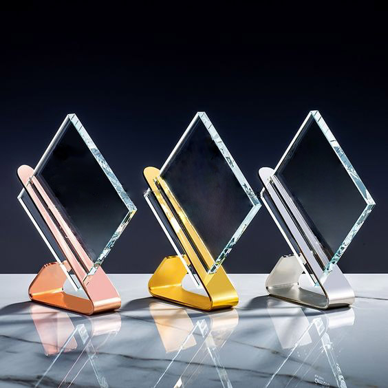 A polished crystal award with a refined, transparent design, elegantly shaped with sharp angles and smooth surfaces with metal finish. The award showcasing a custom design, logo, or text. The crystal reflects light beautifully, creating a brilliant display of clarity and craftsmanship.