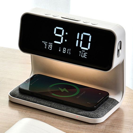 Wireless charger featuring a modern design with an integrated digital clock, customizable RGB lighting, and an alarm function. The device offers fast, cable-free charging for Qi-enabled devices, and the RGB light can be adjusted to various colors and modes for ambiance. The clear digital display shows the time, and the alarm function includes adjustable settings for a personalized wake-up experience.